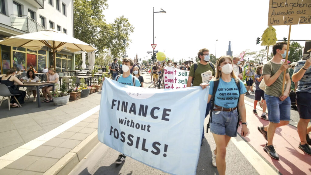 Demonstrantinnen von urgewald beim Protest gegen Investitionen von Kohle und fossilen Brennstoffen mit Transparent "Finance without fossils!".